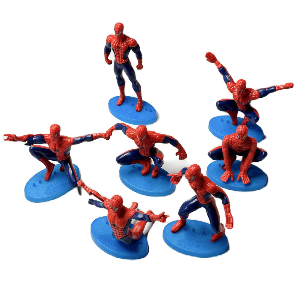 Close-up of 7 Posing Spiderman Cake Toppers arranged on white background