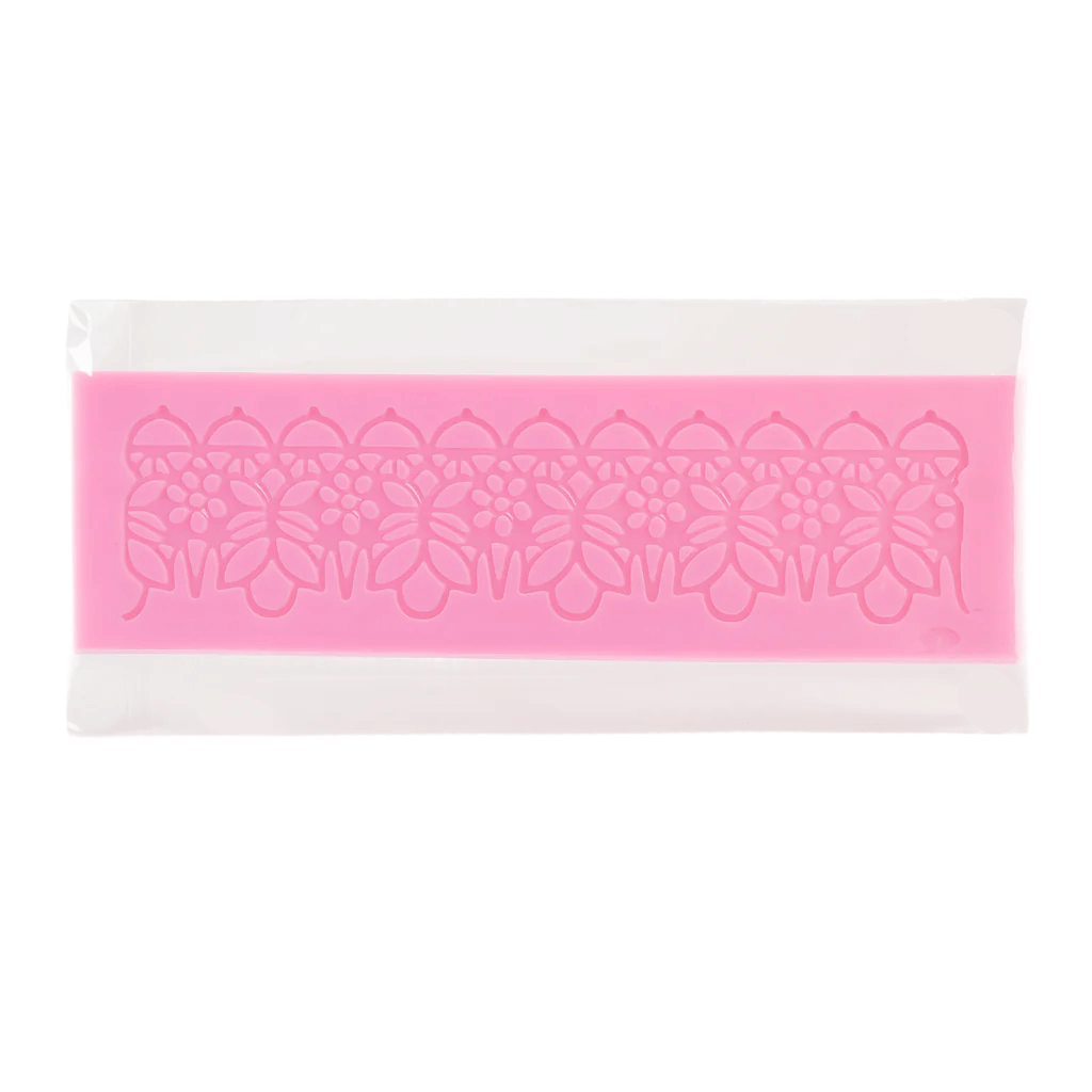 Pink silicone fondant lace mat with floral design on a white background