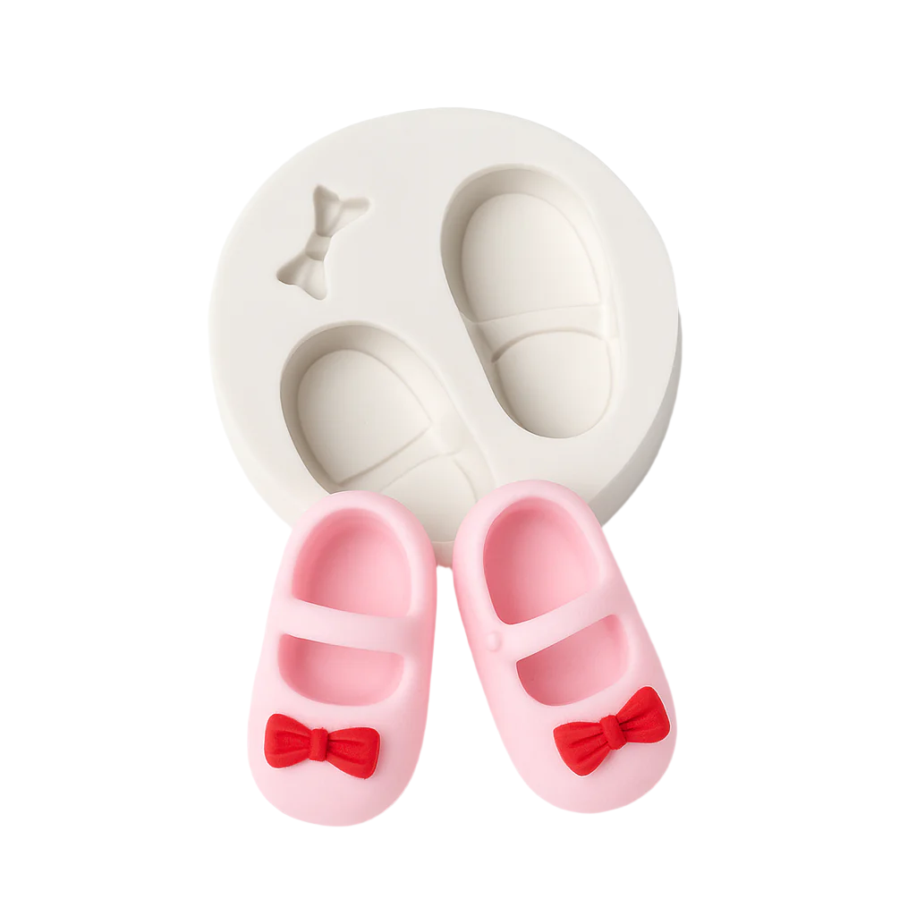Pink shoes with red bows and a white heart-shaped silicone fondant mold on a white background