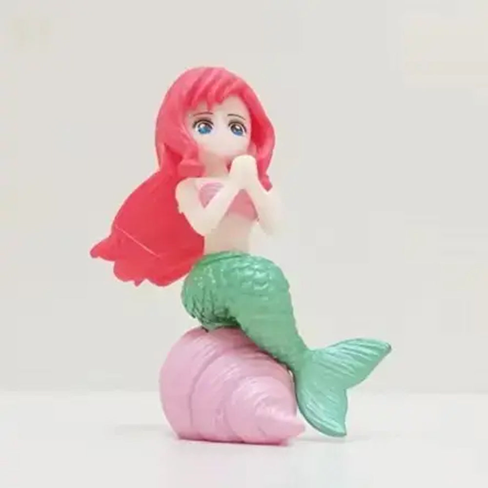 Miniature red-haired mermaid figurine with green tail and pink shell seat – cute ocean-themed cake topper for under the sea birthday parties, mermaid baby shower decorations, and kids’ fondant cake designs.