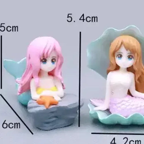Cute miniature mermaid cake toppers with anime-style faces – one with pink hair sitting on a rock holding a starfish (6 cm tall), and the other with orange hair in a seashell with a lavender tail (5.4 cm tall) – perfect for ocean theme birthday cakes and under the sea decorations.
