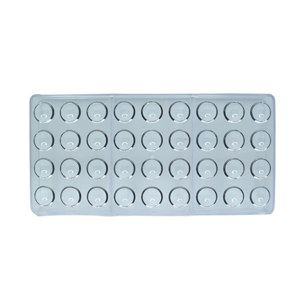 36 in 1 Round Polycarbonate Chocolate Mold placed on a green baking mat against a white background for a detailed view.