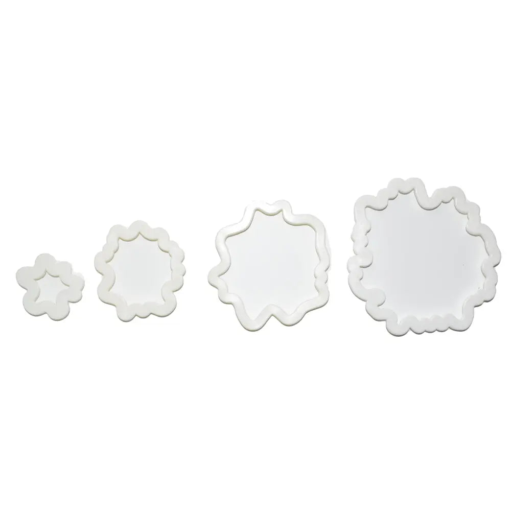 Floral-shaped cutouts from 4 Piece Peonies Cookie & Fondant Cutter set aligned on a white background