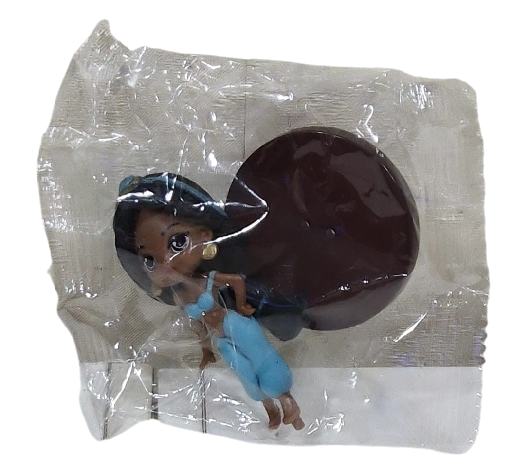 Toy figure of a girl in a blue dress and inside transparent plastic packaging on a transparent background.