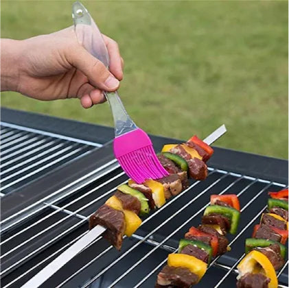 Image displaying the Big Silicone Brush in use for basting barbecue sauce on meat, highlighting its versatility in cooking.
