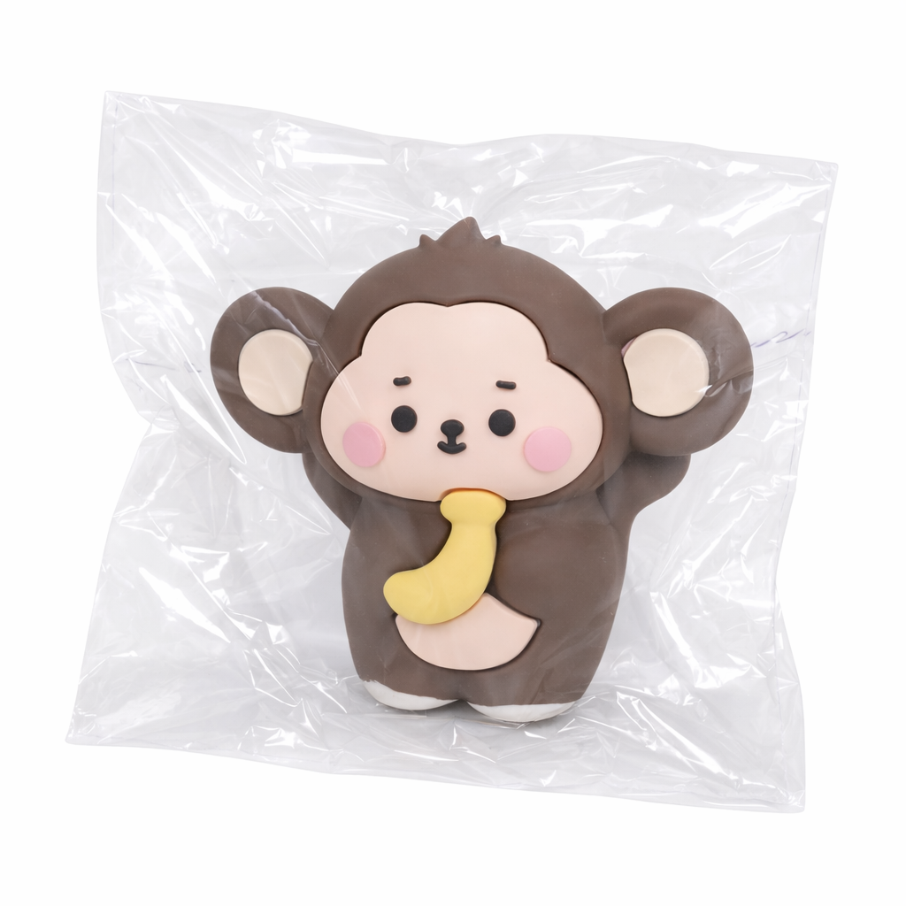 Plush monkey toy with a yellow banana in clear transparent  packaging on a transparent  background