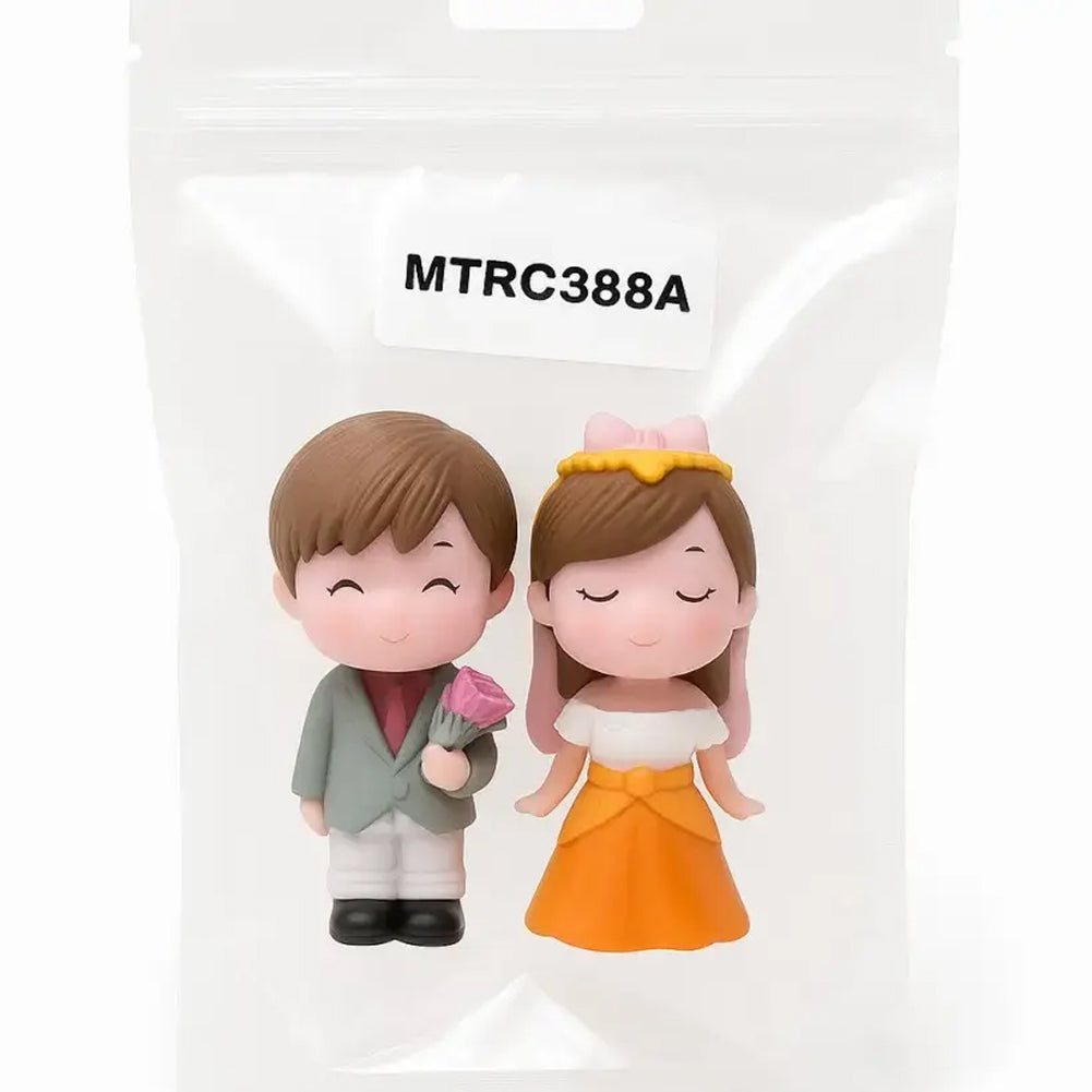 Couple miniature figurines in sealed packaging labeled MTRC388A – boy holding pink flower and girl in orange dress, ideal for romantic cake toppers, wedding decoration, or anniversary party favors.