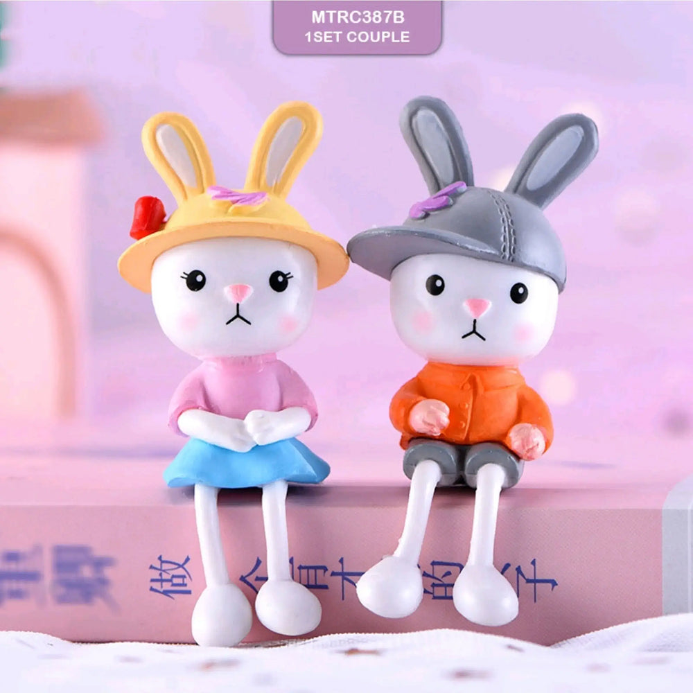 Cute bunny couple miniature figurines – girl bunny in yellow hat and pink top, boy bunny in grey cap and orange hoodie, perfect for baby shower cake toppers, Easter decorations, and cartoon fondant themes.