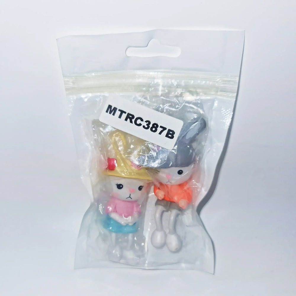 Packaged bunny couple figurines labeled MTRC387B – cute rabbit miniatures with hats, ideal for baby shower cake toppers, kids' birthday themes, and kawaii collectible decorations.