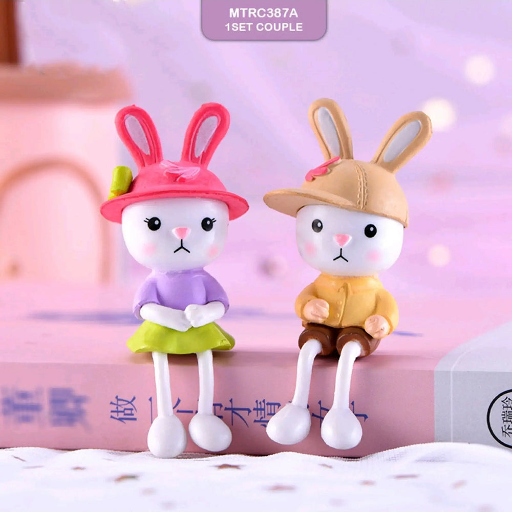 Adorable bunny couple figurines – girl bunny in pink hat and purple top, boy bunny in yellow cap and brown shorts, perfect for kids’ cake toppers, animal party themes, and rabbit decorations.