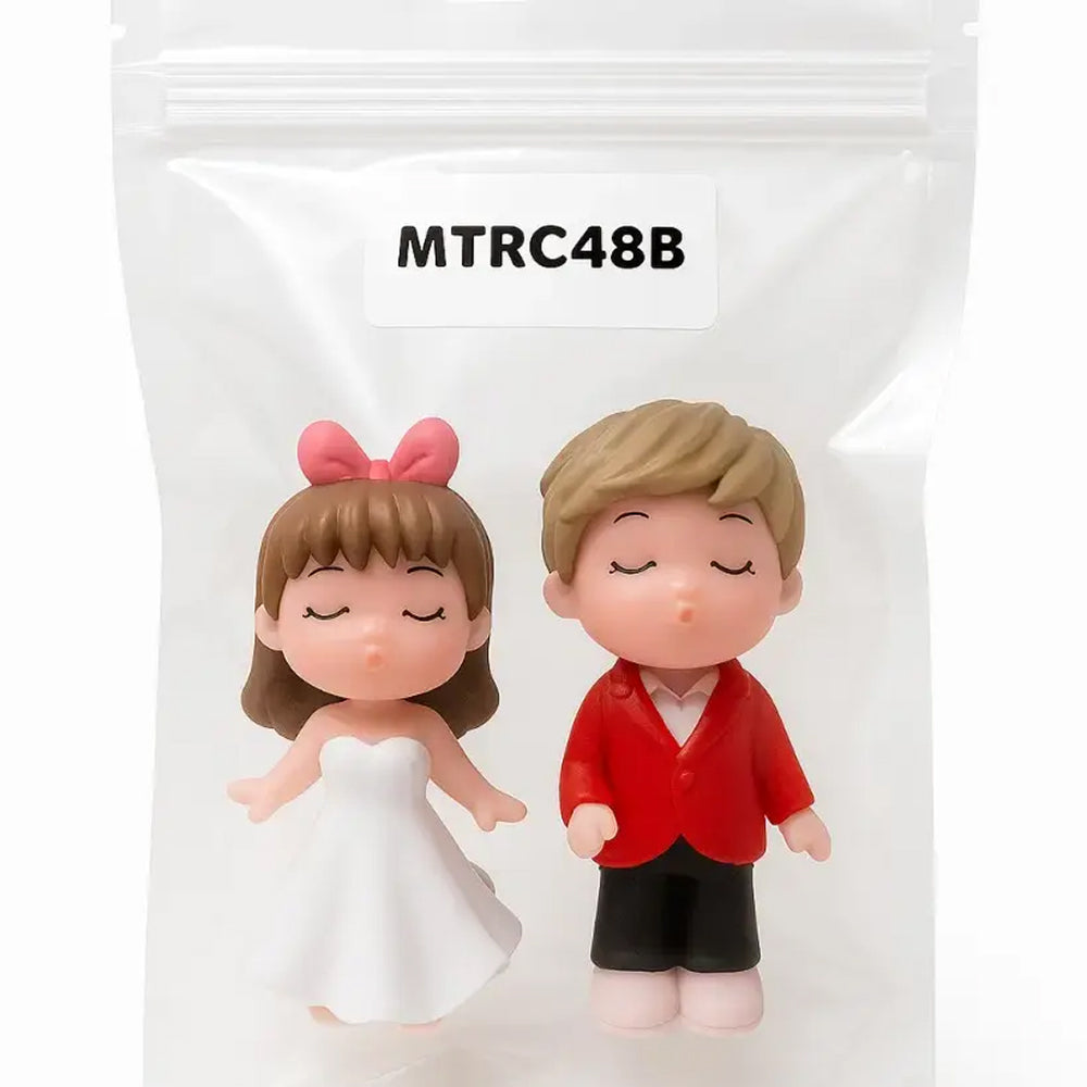 Elegant bride and groom miniature figurines in white dress and red suit, eyes closed, sealed in packaging – perfect for wedding cake toppers and romantic crafts.