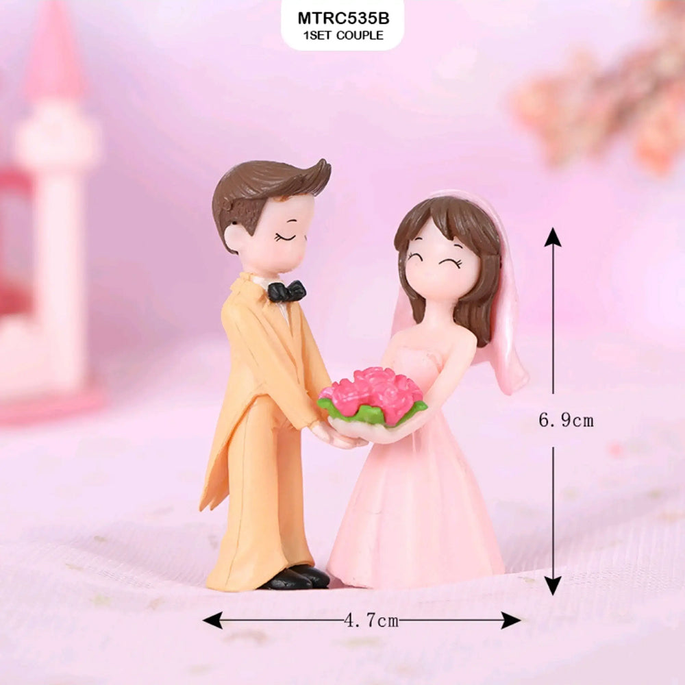 Wedding-themed couple figurines – groom in yellow suit and bride in pink gown holding bouquet, 6.9 cm tall romantic topper for wedding cakes and engagement celebrations.