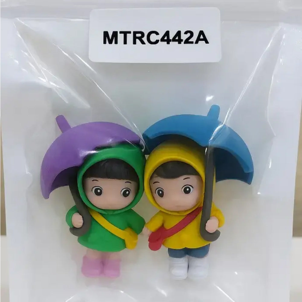 Adorable raincoat couple miniature figurines with colorful umbrellas in transparent packaging – perfect for cake toppers and kids' birthday decorations.