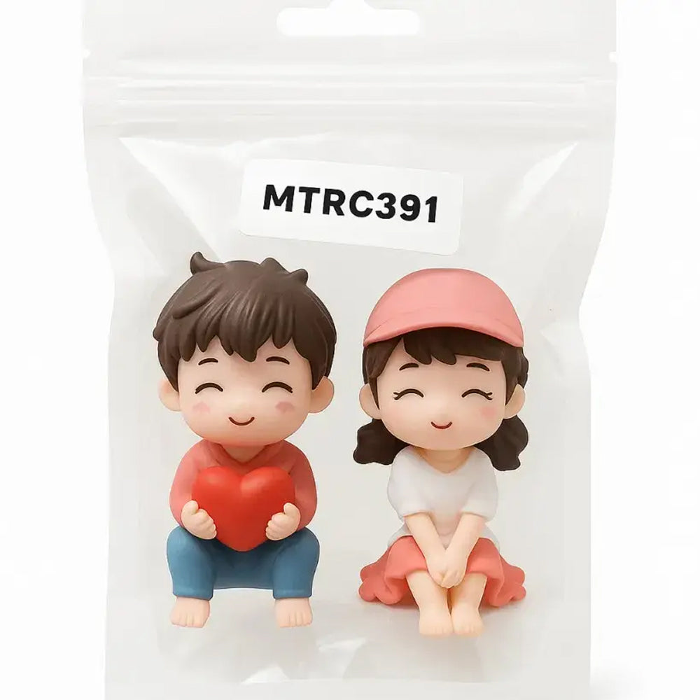 Packaged couple figurine set labeled MTRC391 – cute miniatures of a boy holding a heart and girl in pink cap, perfect for romantic cake toppers and love-themed party favors.