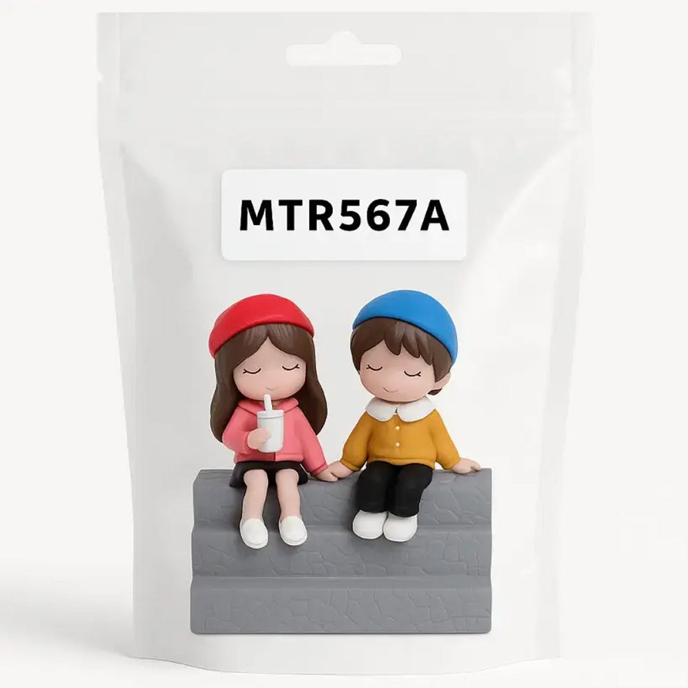 Packaged cake topper figurine set with two girls sitting on a bench, one holding a drink – labeled MTR567A for decorative gifting and cake styling