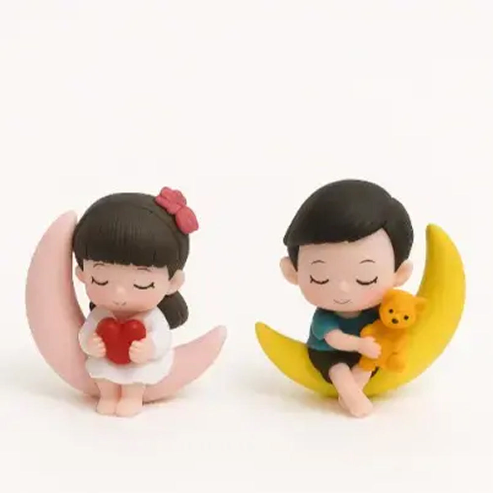 Cute sleeping boy and girl figurine set on moon props, girl holding red heart and boy hugging yellow teddy – ideal for dreamy cake toppers, bedtime-themed decorations, and baby shower cakes.
