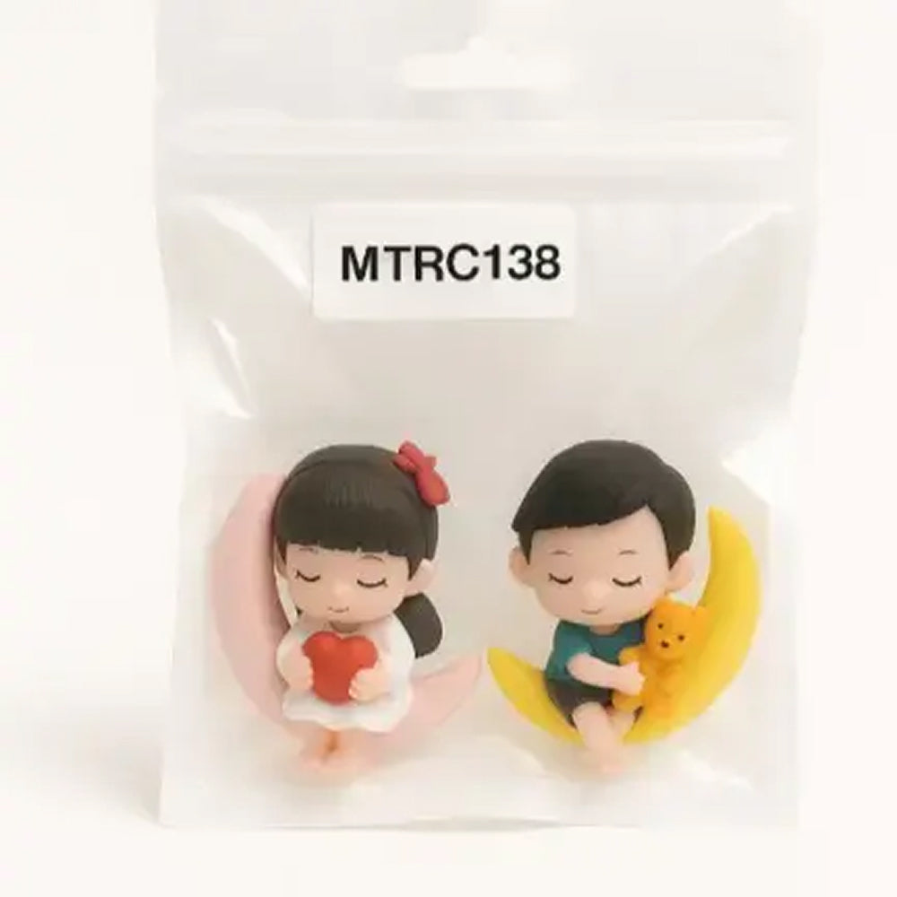 Cute sleeping boy and girl figurine set on moon props, girl holding red heart and boy hugging yellow teddy – ideal for dreamy cake toppers, bedtime-themed decorations, and baby shower cakes.