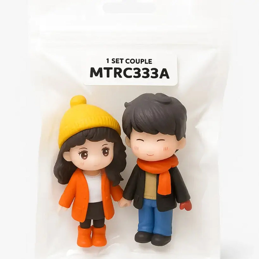Winter couple figurines wearing cozy scarves, jackets, and beanies in sealed pouch – charming cake topper set for seasonal and romantic themes.