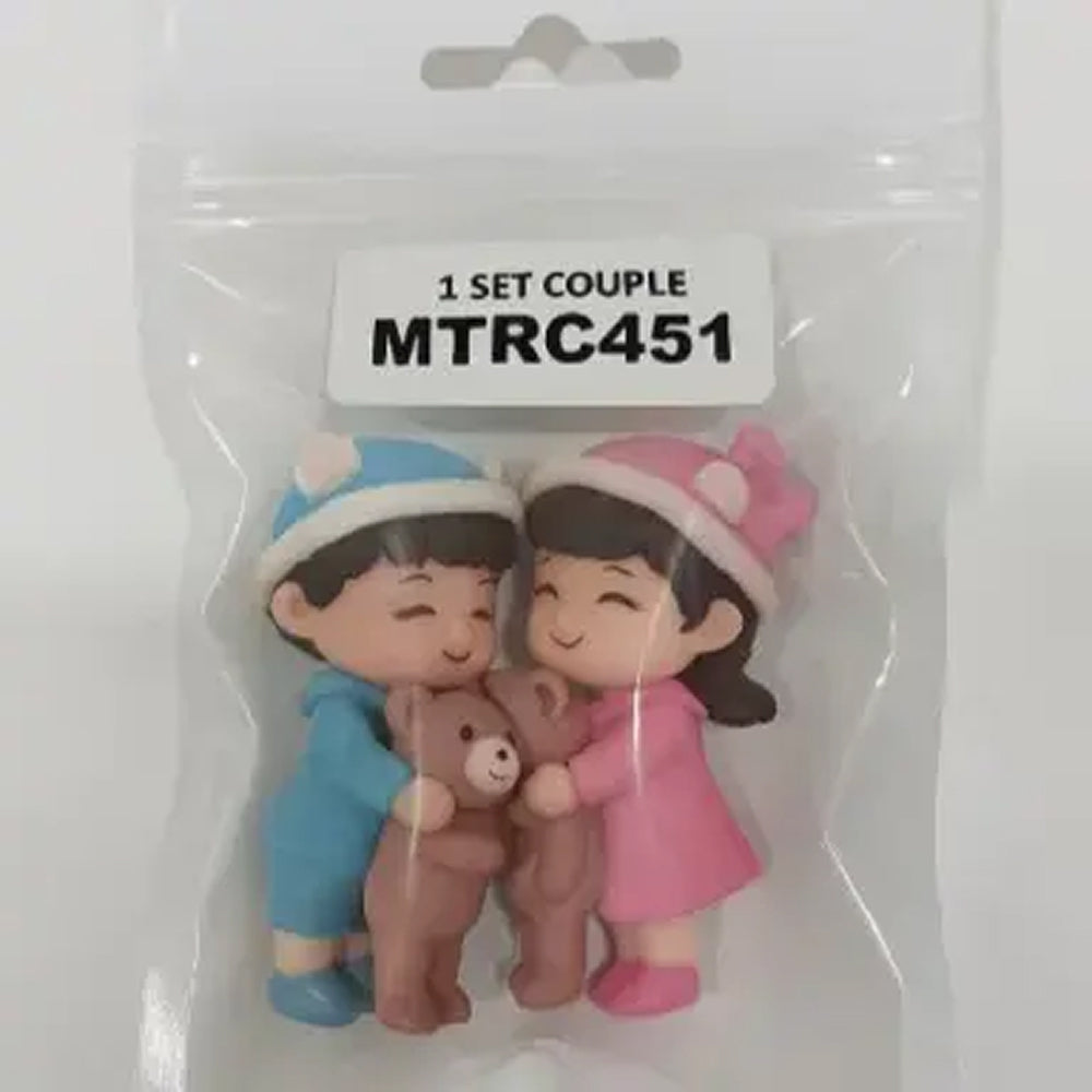 Couple miniature figurines in cozy blue and pink winter outfits holding teddy bears – sealed packaging view – MTRC451 set