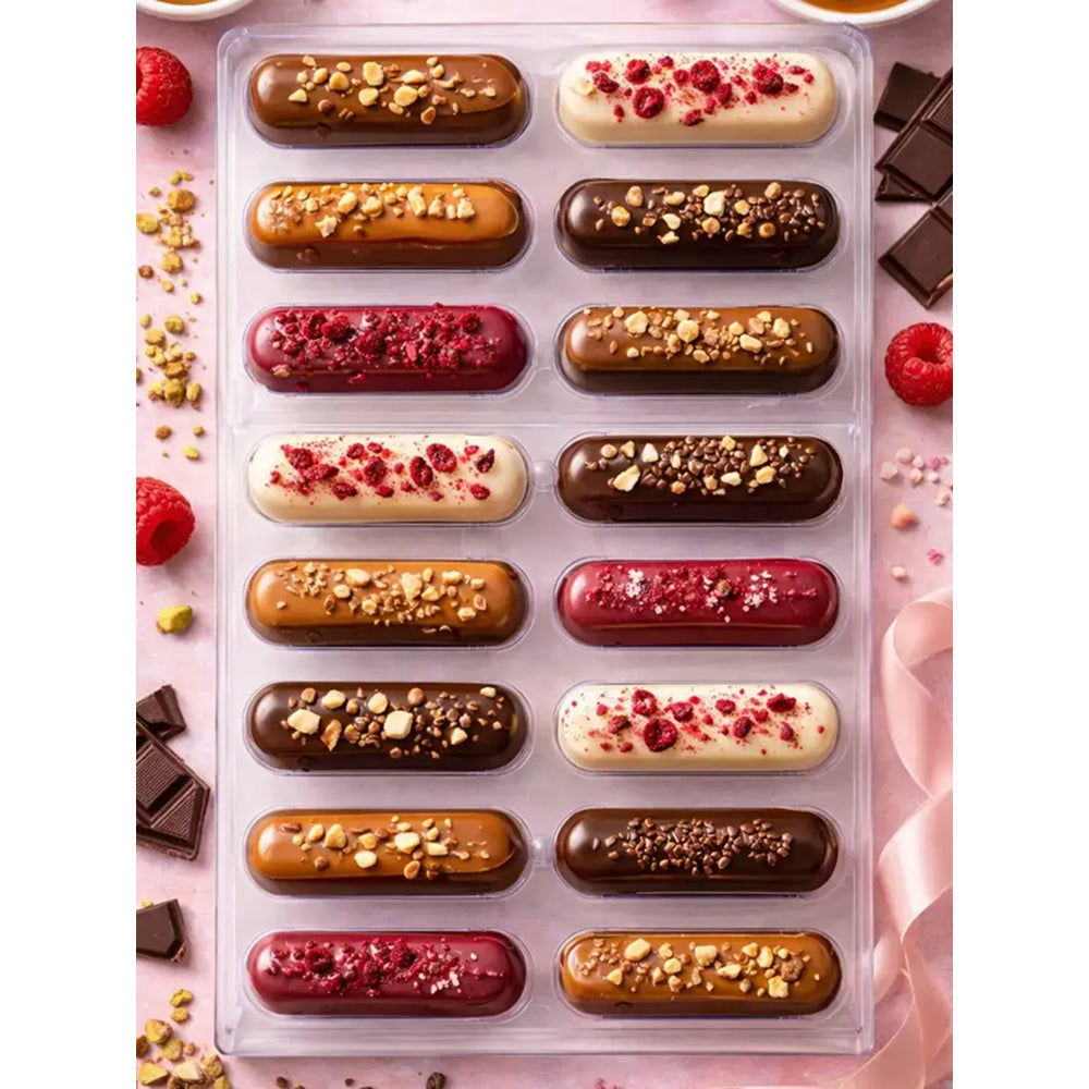 Assorted polycarbonate chocolate truffles in a clear packaging on a pink background with raspberries and chocolate pieces.