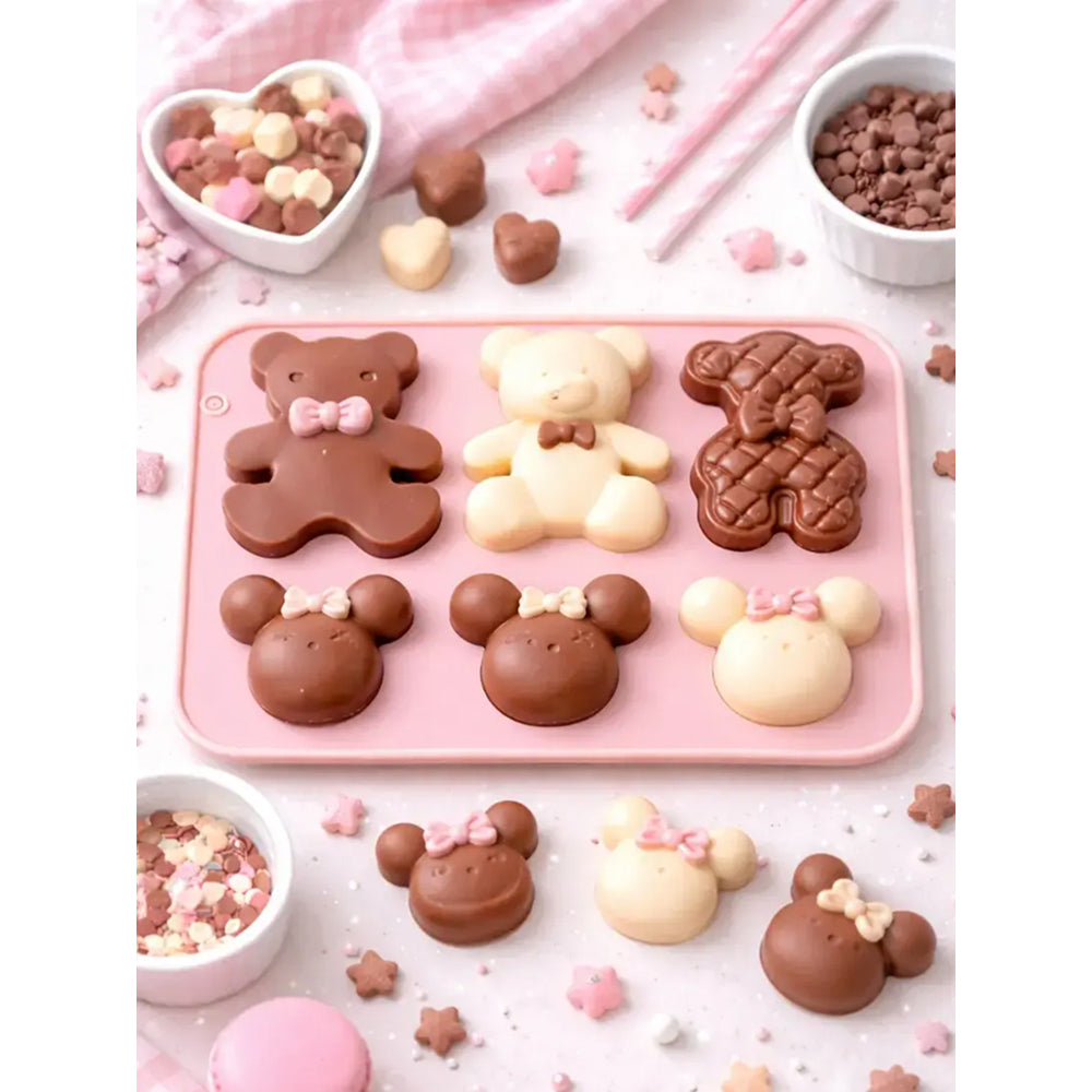 Pink silicone mold with bear, bunny, and mouse designs on a white background with chocolate candies.