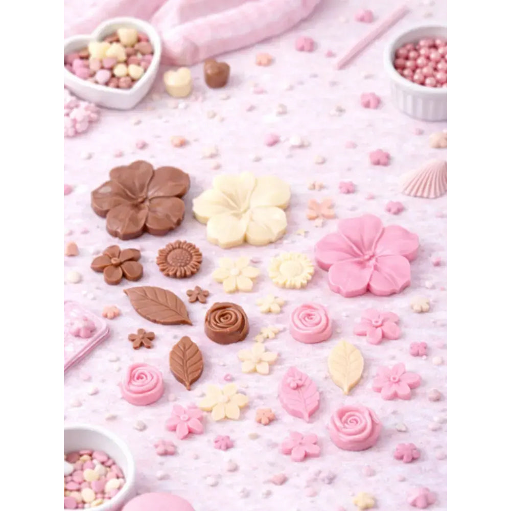 Decorative candies shaped like flowers and leaves on a pink background