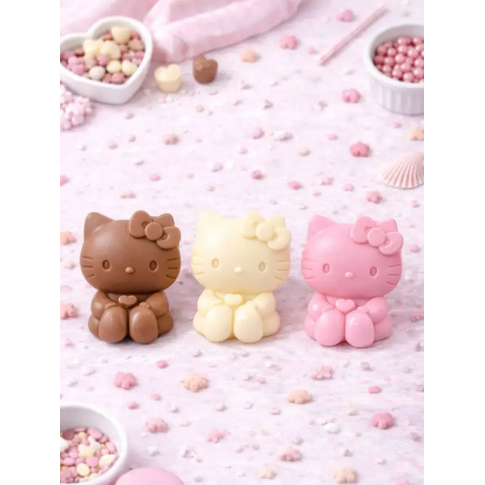 Three Hello Kitty-shaped candies on a pink background with small heart-shaped bowls of candy.