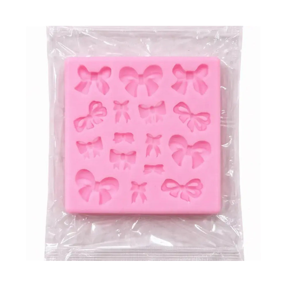 Pink silicone mold with bow shapes in clear packaging on a white background