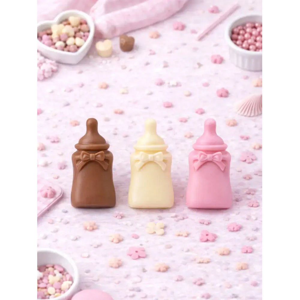 Three baby bottle-shaped candies in brown, yellow, and pink on a pink background with decorative elements.