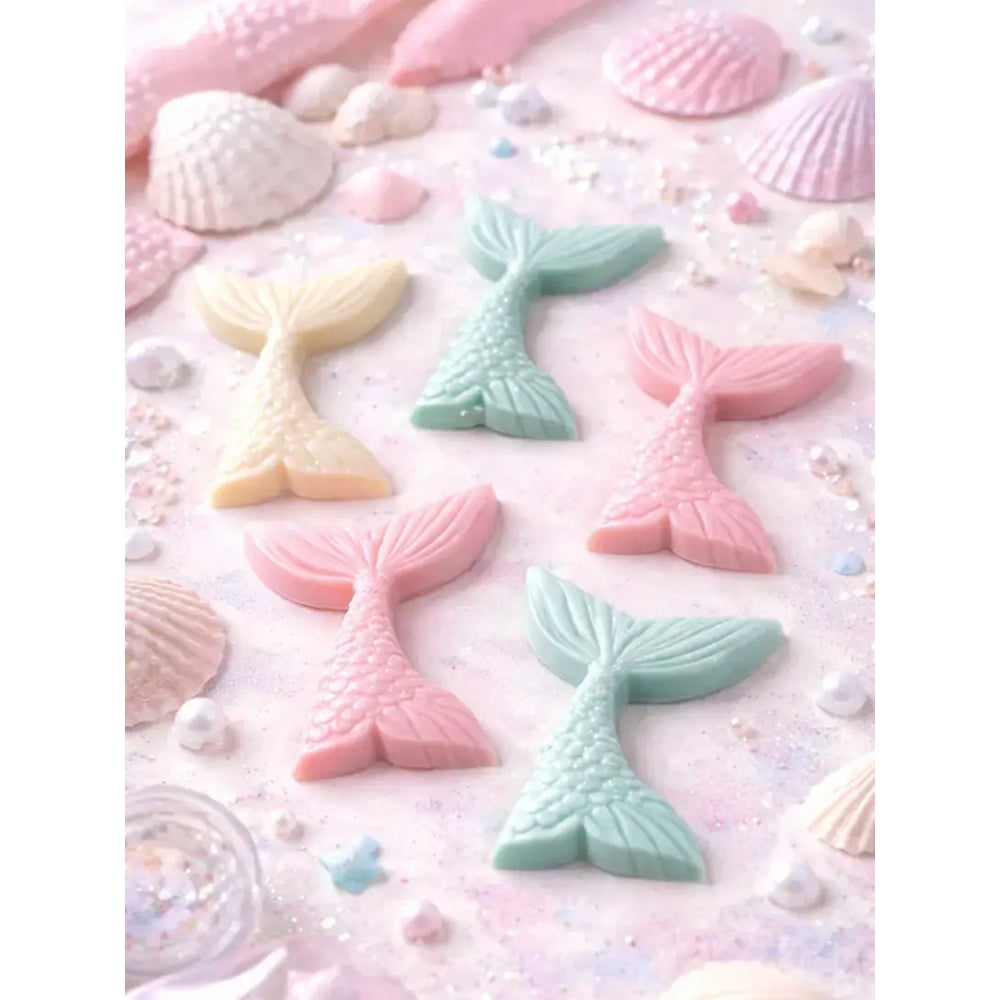 Pastel-colored mermaid tail candies on a pink background with shells and pearls.