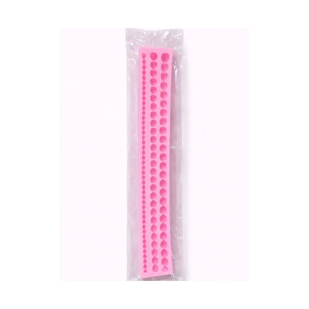 Pink silicone mold with circular shapes in a clear plastic packaging on a white background