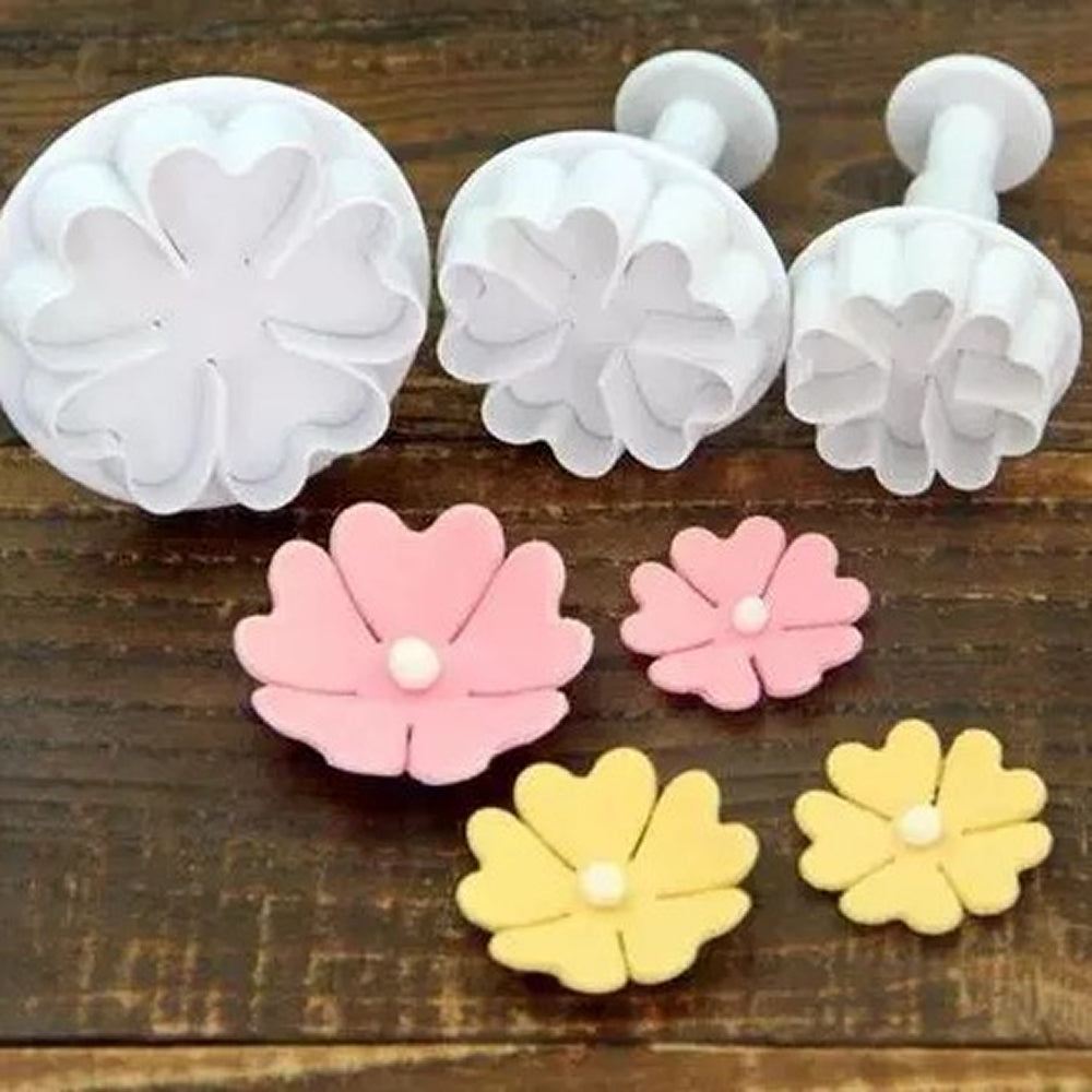 Set of flower-shaped cookie cutters on a wooden surface