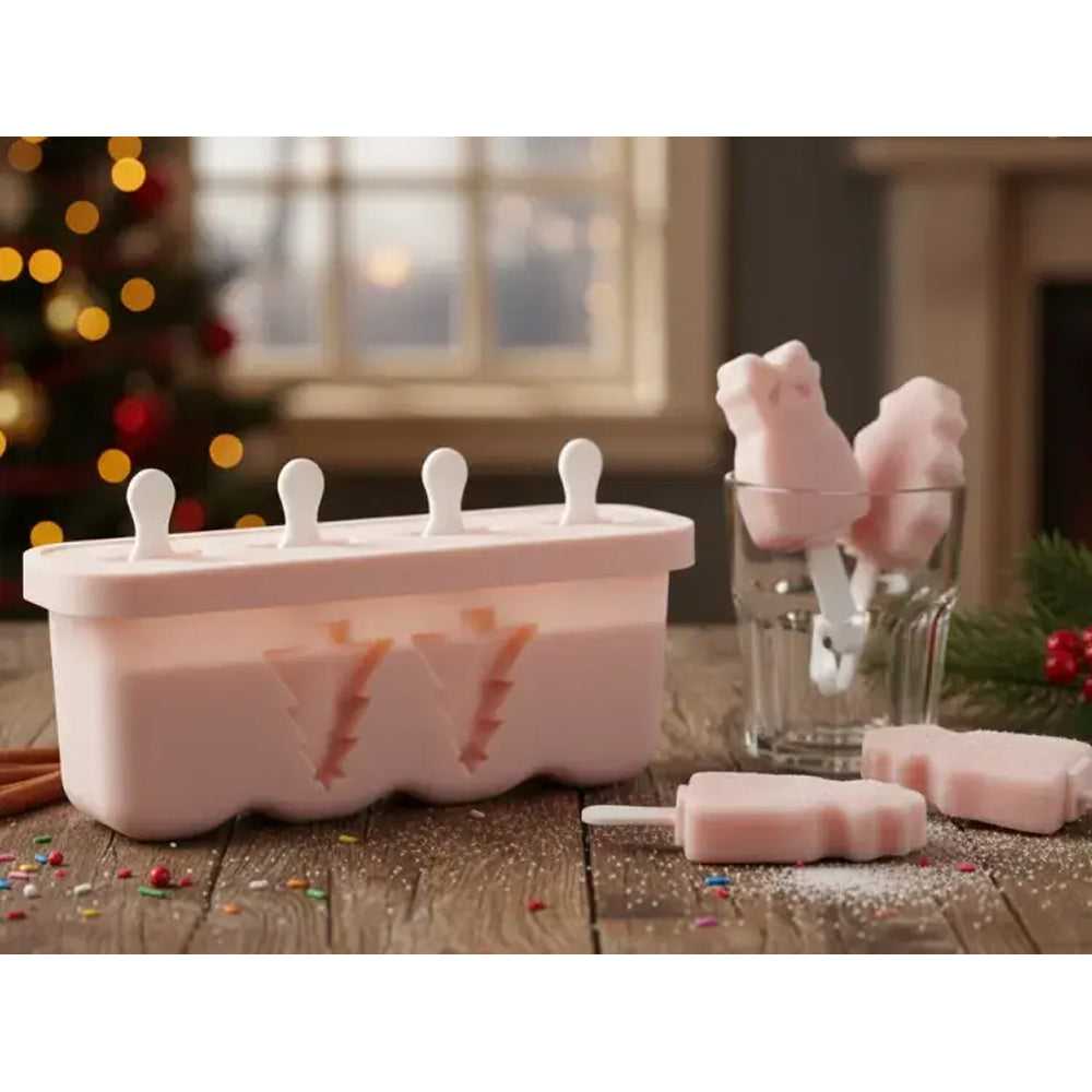 Pink popsicle mold with popsicles on a wooden surface, Christmas tree in the background