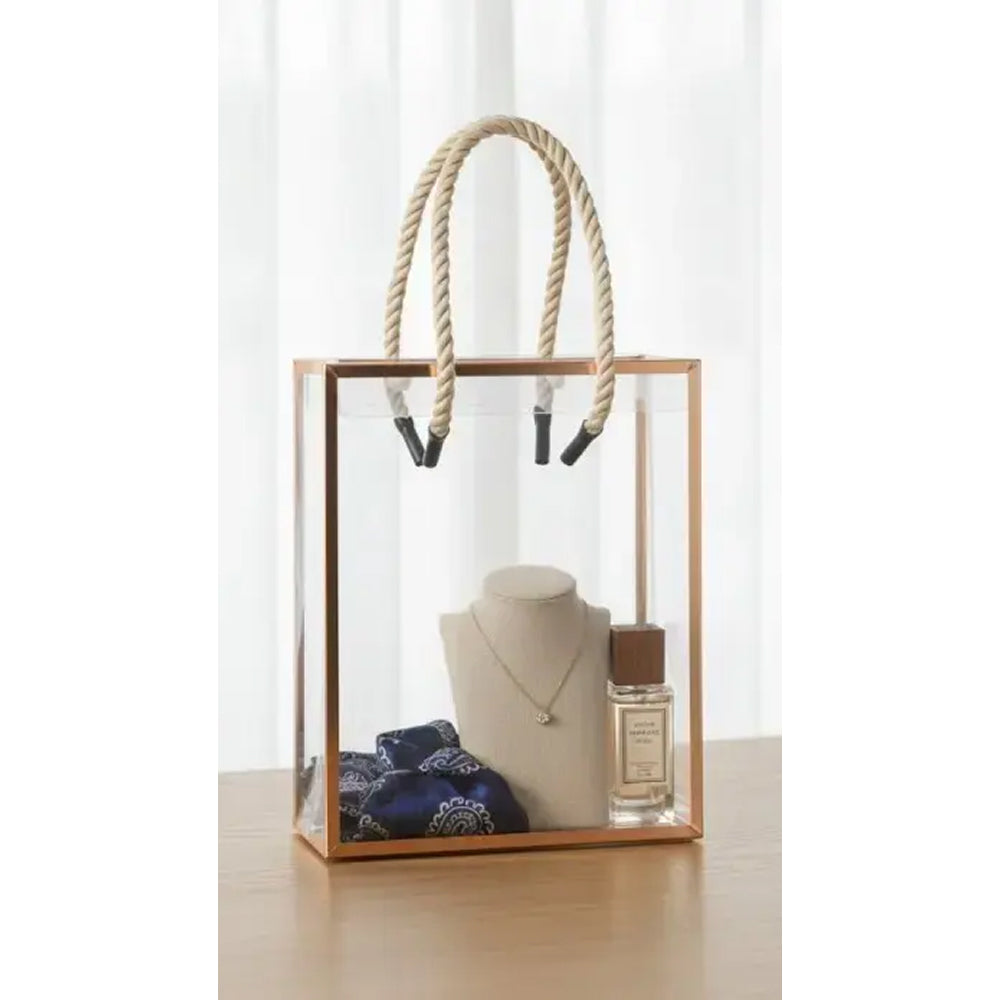 Clear glass display case with wooden frame and rope handles, containing a necklace and perfume bottle on a white background.