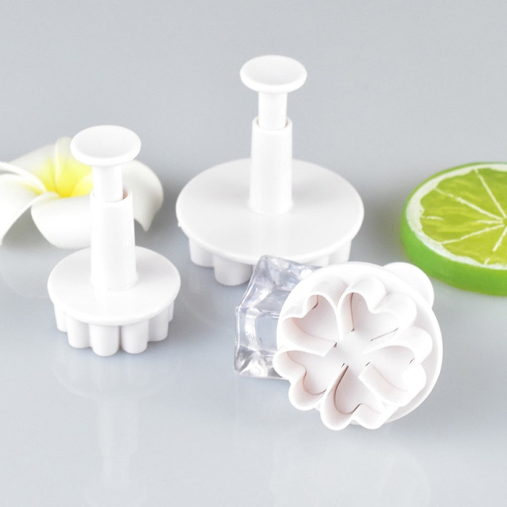 Set of white plastic flower-shaped tools on a gray background with a lime wedge.