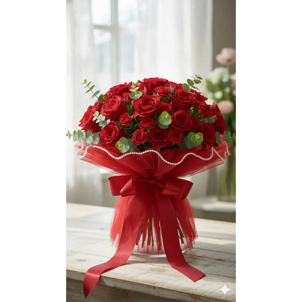 Bouquet of red roses with a red ribbon on a wooden surface.