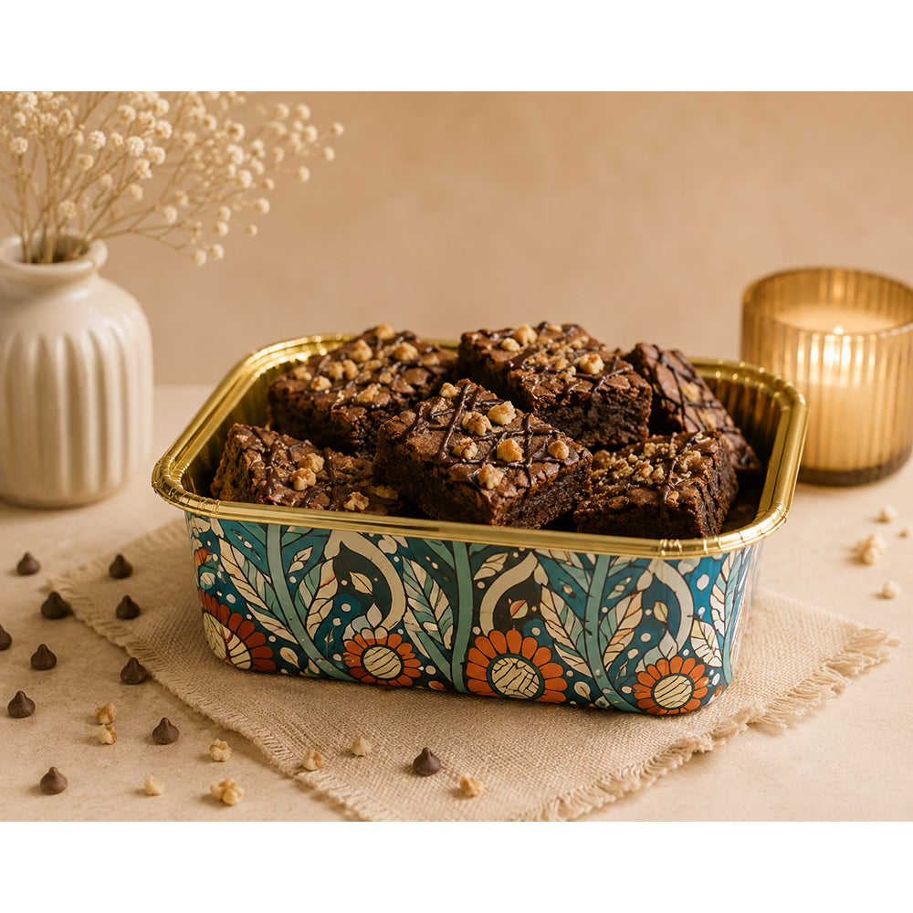 Decorative Square Muffin Cup container with brownies on a table with a vase and candle in the background
