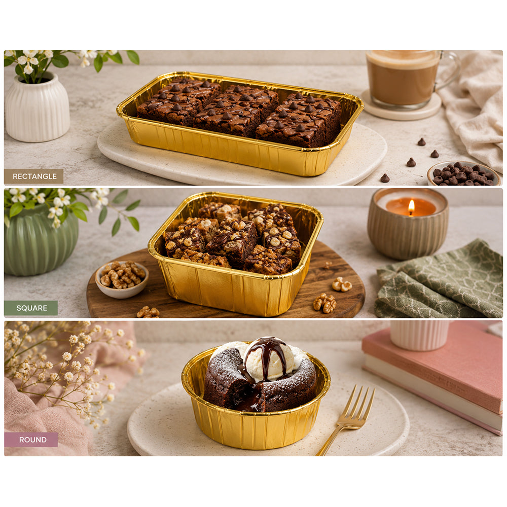 Three different shapes of brownies in gold Premium Paper containers on a table with a candle and flowers.