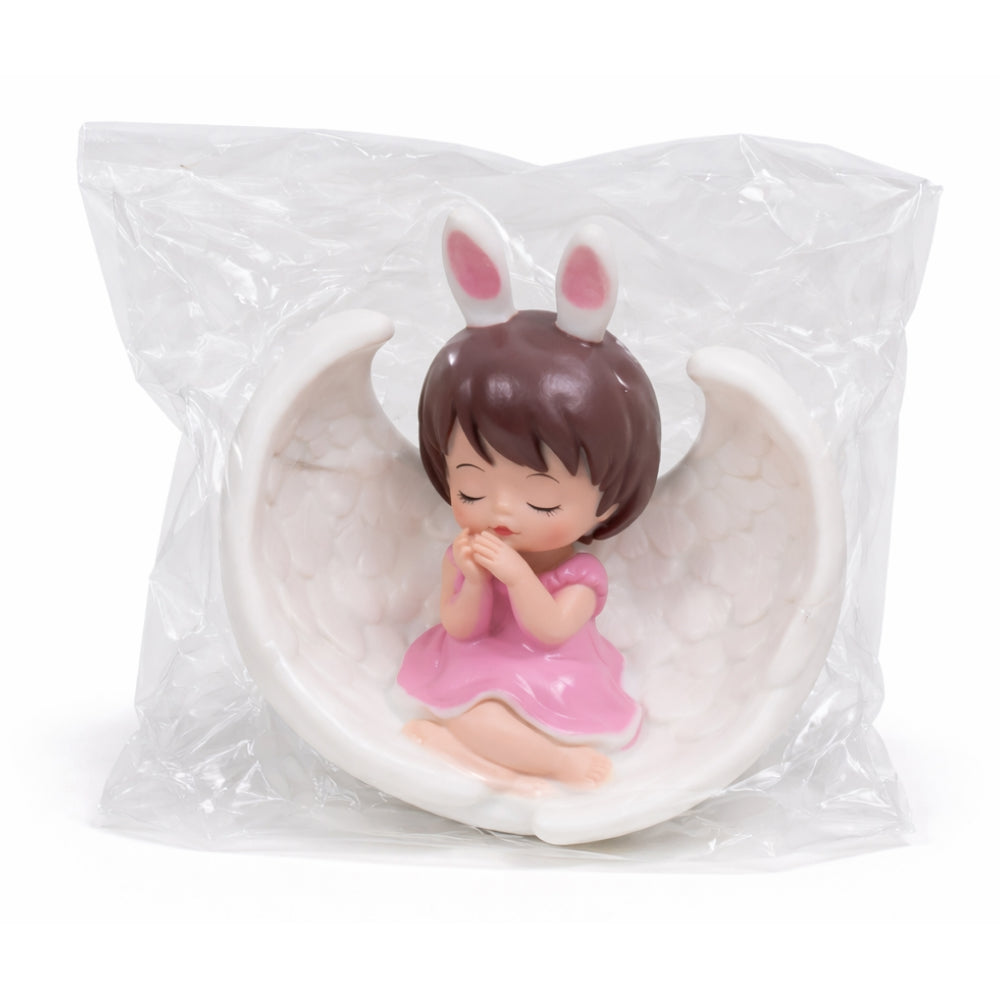 Figurine of a girl with bunny ears sitting on a moon, still in packaging.