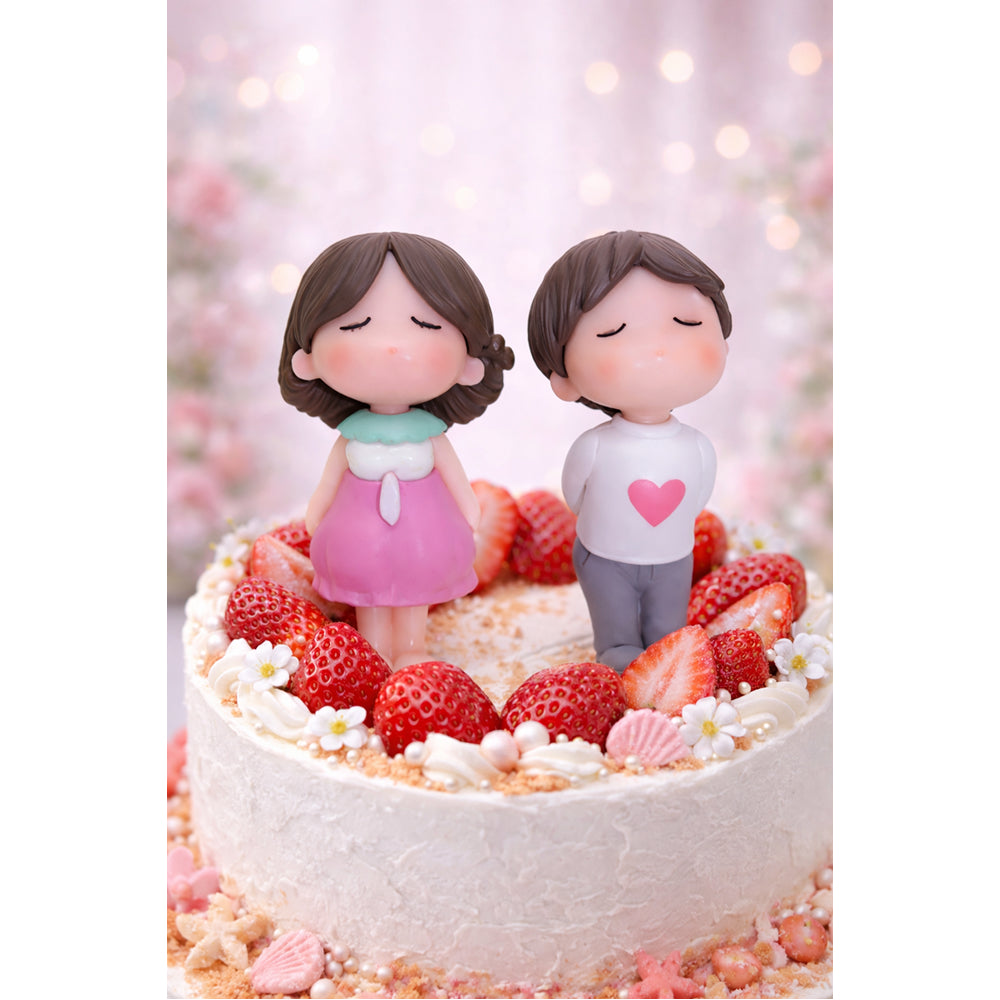 Decorative cake with Miniatures of a couple on top, surrounded by strawberries and pink flowers.