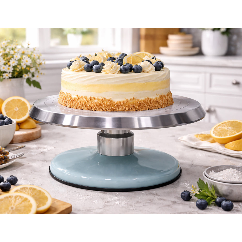 Cake on a turntable with lemon and blueberry decorations in a kitchen setting