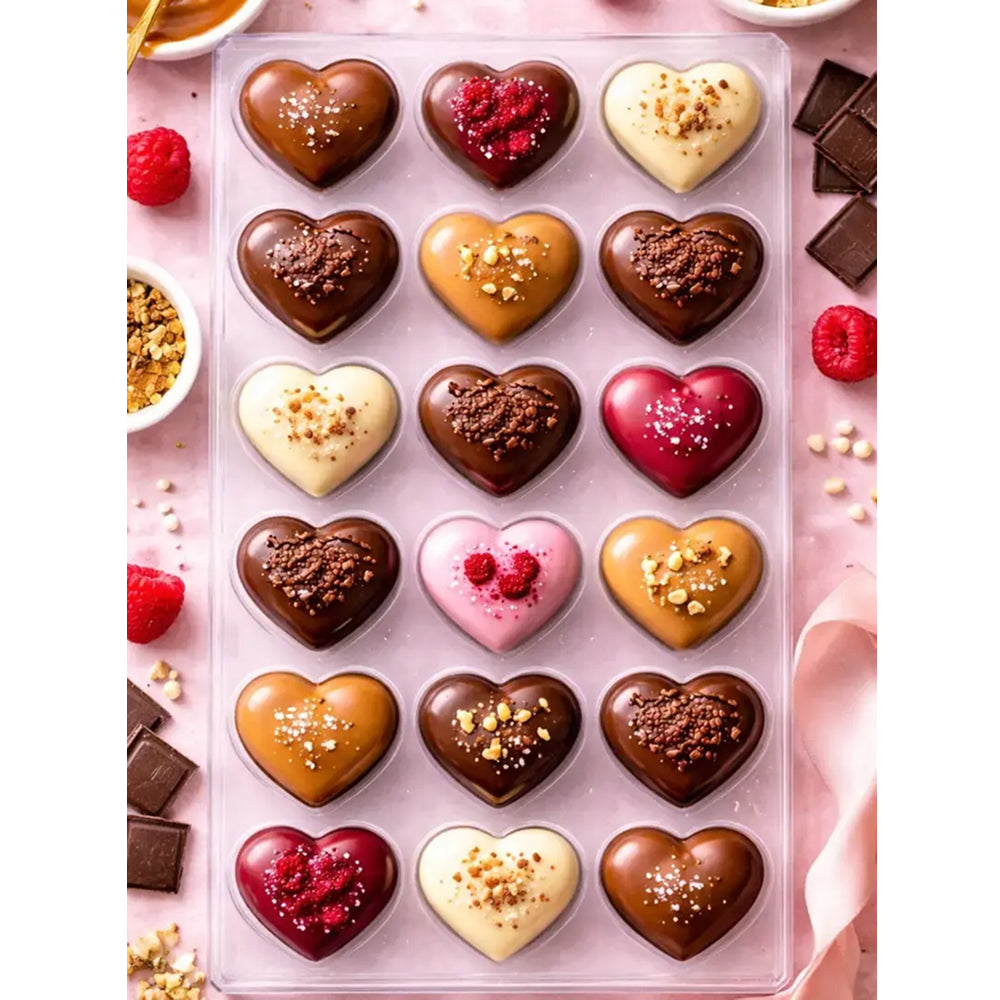 Assorted heart-shaped chocolates in a Polycarbonate mold with a pink background