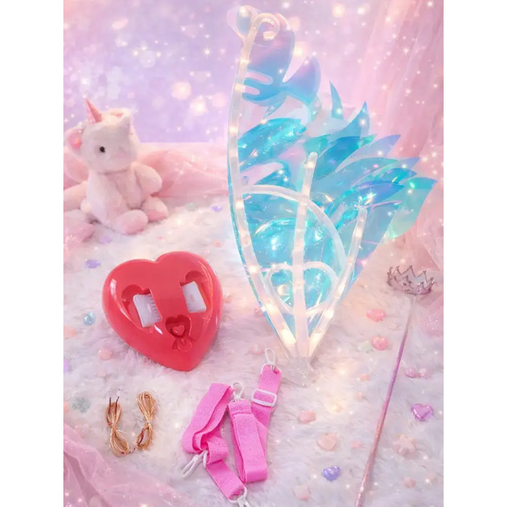 Butterfly accessories including a heart-shaped clip, fairy wings, and a unicorn toy on a soft pink background.