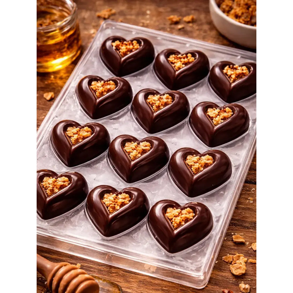 Polycarbonate chocolate heart shape with a crumbly topping on a wooden surface.