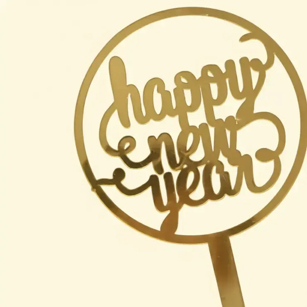 Gold 'Happy New Year' cake topper on a beige background