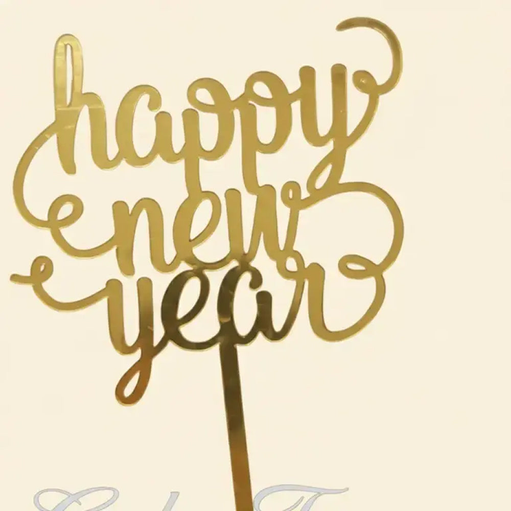 Gold 'Happy New Year' cake topper on a beige background