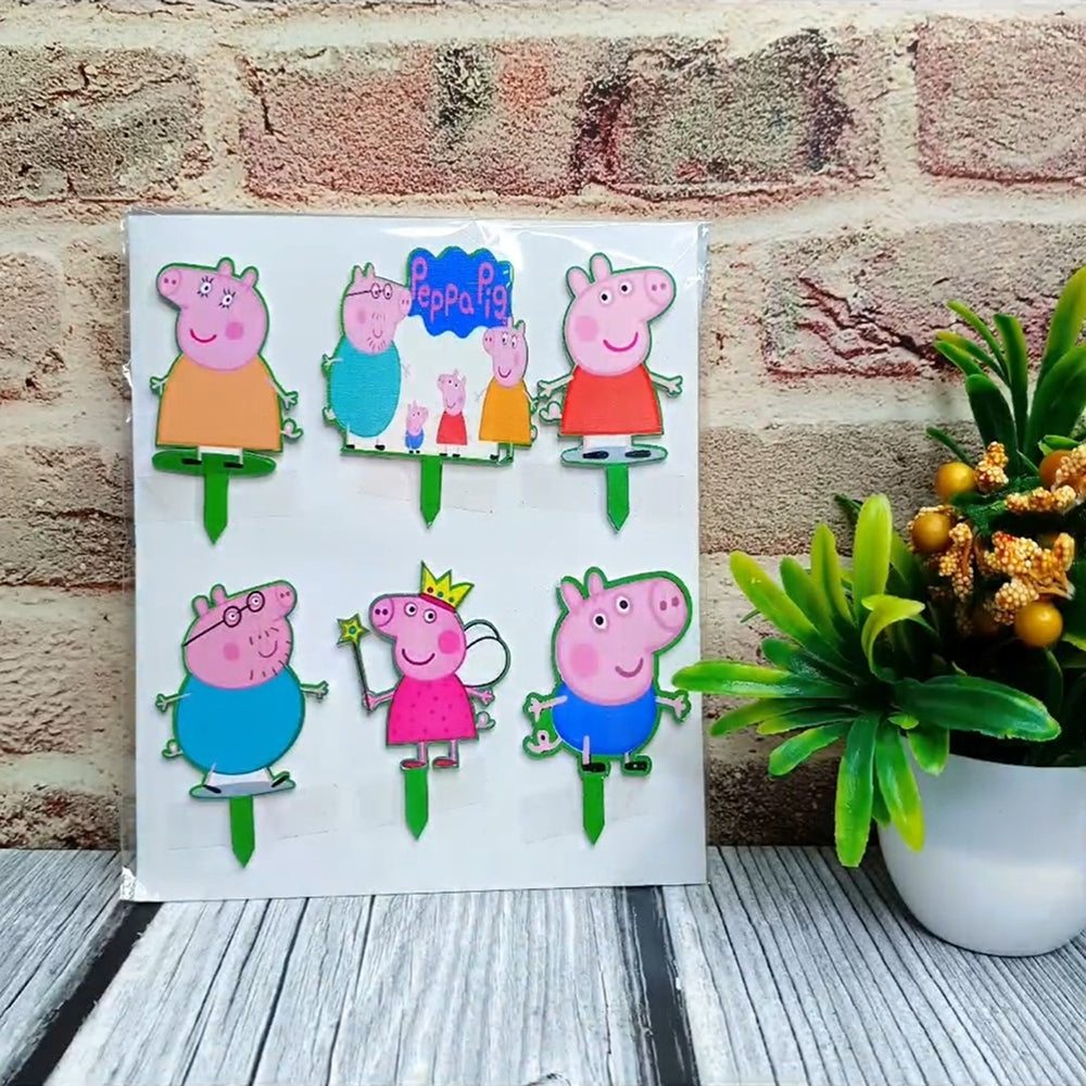 Colorful Peppa Pig family stickers on a white card against a brick wall background.
