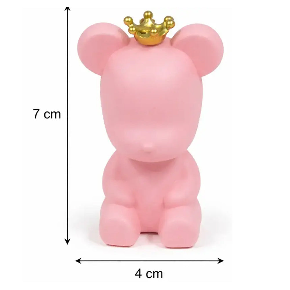 Pink bear figurine with a gold crown and measurements on a white background