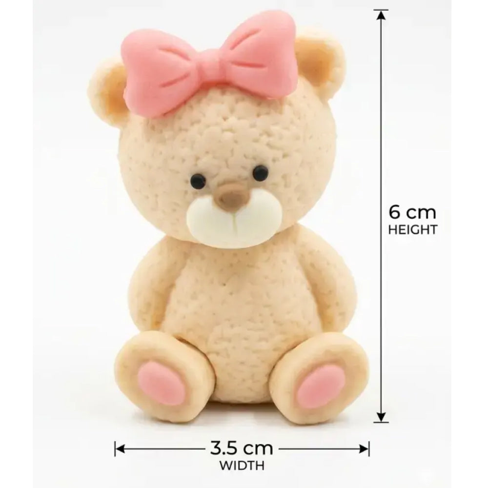 Small teddy bear with a pink bow, showing measurements on a white background