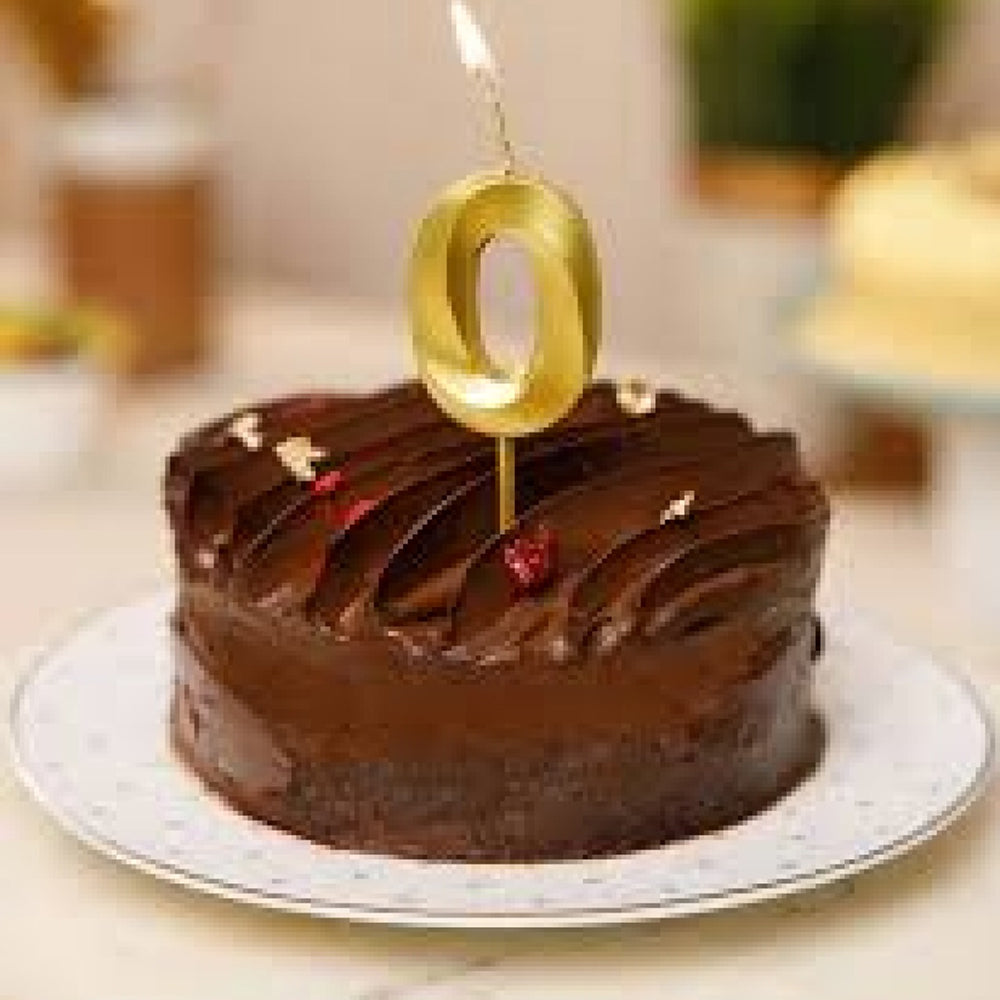 Close-up of Golden Number 0 Candle lit on cake during celebration
